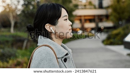 Japanese woman, earphones and walk in street with listening, music and streaming subscription in city. Business person, audio tech and sound for podcast, radio and travel on metro sidewalk in Tokyo