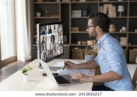 Worldwide communication use modern tech and videocall application. 35s businessman sit at desk staring at pc screen take part in videoconference, listens participants involved in remote negotiations Royalty-Free Stock Photo #2413856217