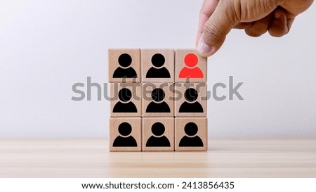 businessman's hand choose red person and focus sign on wooden cube block for human resource, outstanding leadership concept