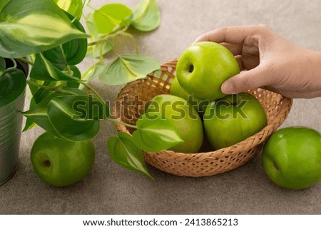 Fresh juicy delicious Taiwanese Milk Indian Jujube fruit in a basket on gray table background. Royalty-Free Stock Photo #2413865213