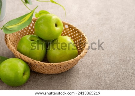 Fresh juicy delicious Taiwanese Milk Indian Jujube fruit in a basket on gray table background. Royalty-Free Stock Photo #2413865219