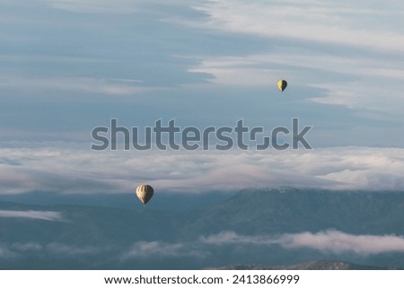 La Garrotxa Landscape from above with two hot air balloons flying flying over the clouds and the volcanic zone. Horizontal picture.