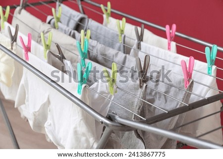 Clean white clothes hanging on dryer, closeup