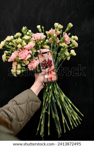 Bouquet of the flowers on a mobile phone screen with a picture of a large bouquet of flowers Tenderness and passion in one bouquet