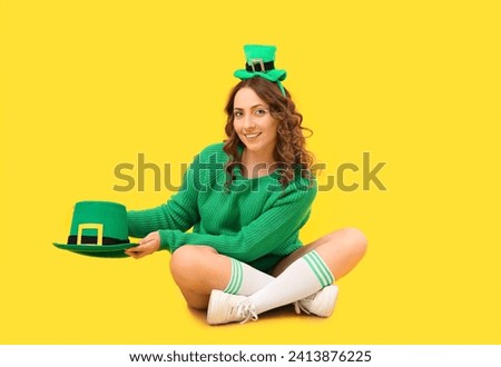 Happy woman with green hat on yellow background. St. Patrick's Day