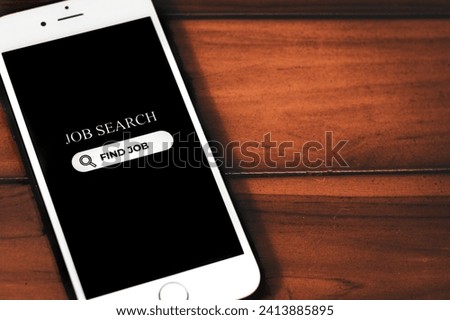 Job Search Concept. Smartphone with job search app on screen on wooden background. Browsing job opportunities online.