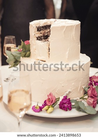 The wedding cake. Wedding Cake with blur bride and groom background. Wedding cake with luxury decorated in wedding party. White, three-tiered, decorated with flowers.