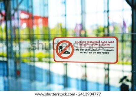 Warning sign do not lean on the glass