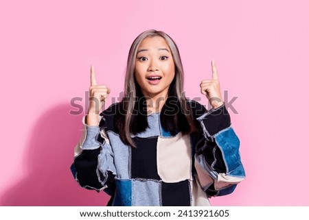 Portrait of impressed woman with dyed hairdo wear oversize sweatshirt indicating at discount empty space isolated on pink color background