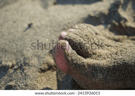 foot covered in sand on the beach. High quality photo