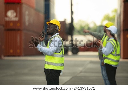 Group of engineers working with laptop in the container yard. This is a freight transportation and distribution warehouse. Royalty-Free Stock Photo #2413931571