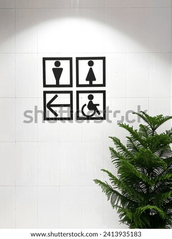 Solid black toilet sign in white wall