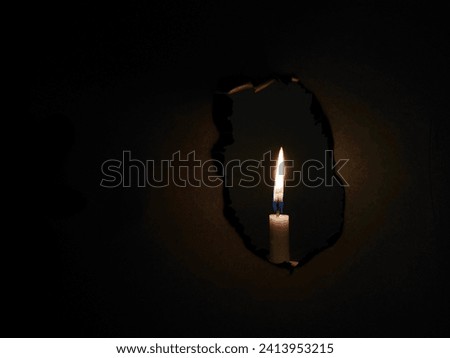 A candle burning paper isolated on a black background
