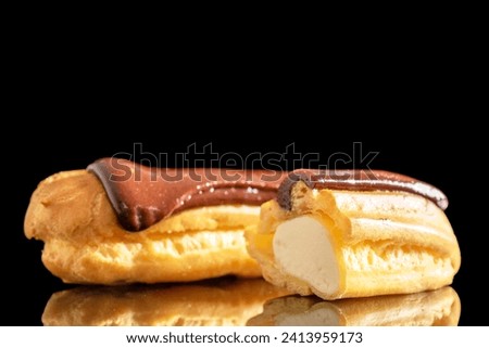One whole and one half delicious chocolate eclair, close-up isolated on black. Royalty-Free Stock Photo #2413959173
