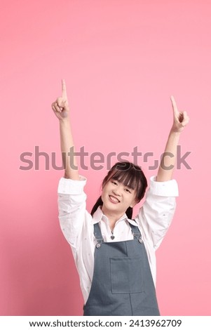 Cheerful lovely young asian woman in overalls casual clothes with gesture of hands pointing isolated on pink background. St Valentine's Day, Women's Day, Birthday