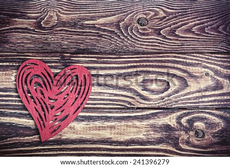 red heart made of felt on the wooden background. toning image
