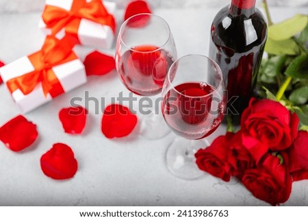 Valentine's Day concept. Valentine's Day background. Gifts, candles, confetti, envelope - postcard, sweets, glasses, wine and a bouquet of roses on a marble background. Flatley, top view.