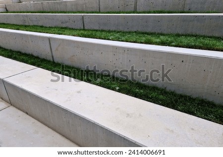 concrete staircase is new and smooth. seating stairs for students and people in the park. lawn benches and beds with perennials in combination with building element, auditorium, school yard, classroom Royalty-Free Stock Photo #2414006691