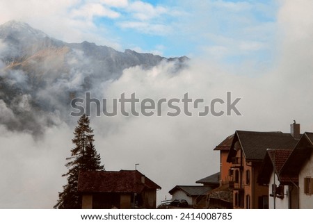 Clouds and Peaks: A Village Morning at the Foot of Whispering Alpine Giants