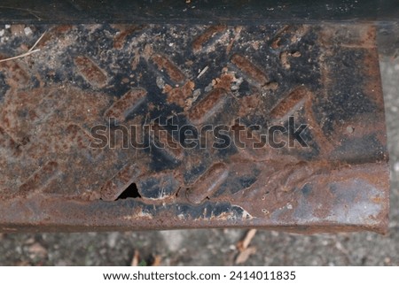 Old iron plates whose paint is dull and starting to rust, there are parts that are scratched and damaged.