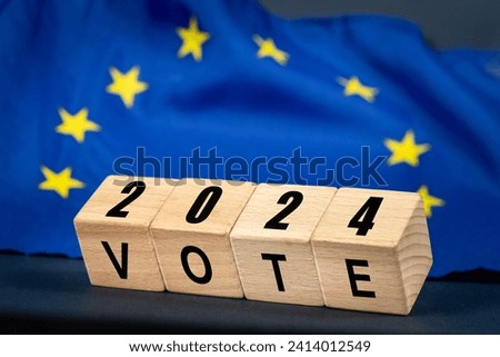 European Union vote, the word Vote on wooden blocks against the background of the EU flag, the concept of voting and taking part in the European elections Royalty-Free Stock Photo #2414012549