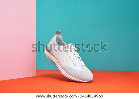 Fashion white sneaker with leather accents on a pastel gradient background. Sport shoe, street wear in air. Product photo or levitation concept.