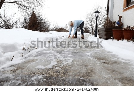 Risk of slipping on an icy sidewalk in winter Royalty-Free Stock Photo #2414024089