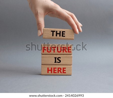 The future is here symbol. Concept words The future is here on wooden blocks. Beautiful grey background. Businessman hand. Business and The future is here concept. Copy space.