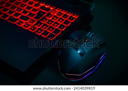 Mouse and notebook gamer isolated in black table  Royalty-Free Stock Photo #2414039819