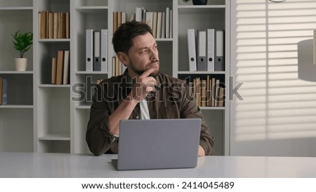 Pensive thoughtful Caucasian man work with laptop in office male writer journalist web designer employee businessman business manager think ponder consider deep thoughts thinking idea typing article Royalty-Free Stock Photo #2414045489