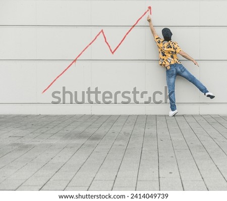 Digital composite of young man drawing a line graph at a wall