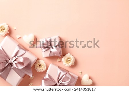 Happy Valentine's day flat lay composition with gift boxes, candles, flowers on beige background. Top view.