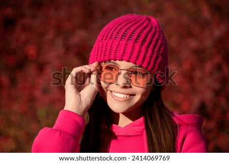 Girl in autumn style outdoor. Fall style fashion. Autumn leaves and happy young girl wearing sunglasses in forest. The color and mood of autumn. Teenager girl in the autumn park. Fall concept