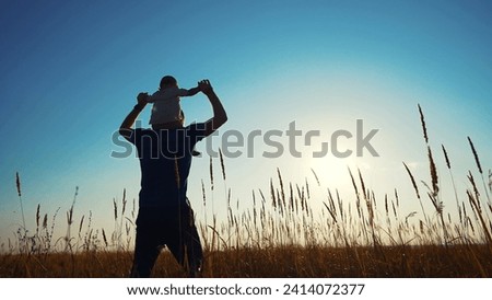 father and son in the park. father's day silhouette happy family child dream concept. father carries his son on his back. dad walk with his son in nature in park silhouette at sunset lifestyle