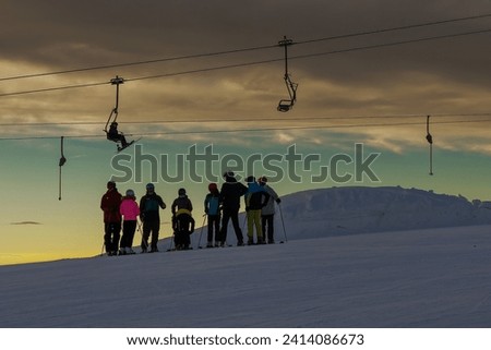 silhouettes of skiers on the hillside