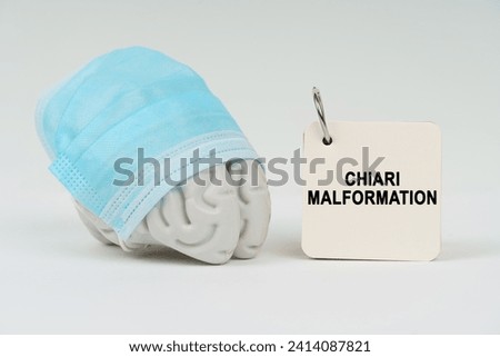 Medical concept. On a white surface next to the brain there is a notepad with the inscription - Chiari malformation Royalty-Free Stock Photo #2414087821
