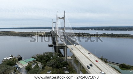 The Dames Point Bridge in Jacksonville, Florida, captured in daylight with cars driving over and water underneath.