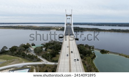 The Dames Point Bridge in Jacksonville, Florida, captured in daylight with cars driving over and water underneath.