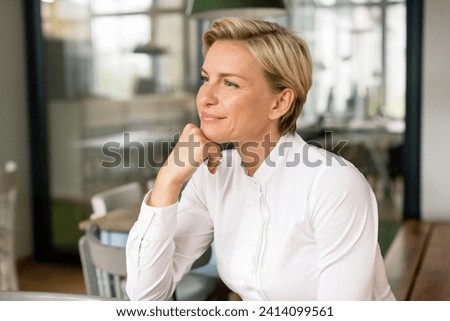 Portrait of confident blond woman looking sideways Royalty-Free Stock Photo #2414099561