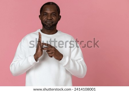Deaf mute black man wearing white sweatshirt gesturing sign language Royalty-Free Stock Photo #2414108001