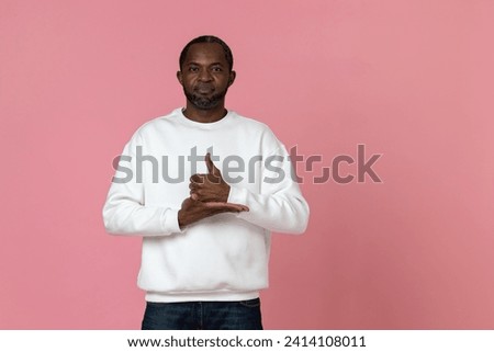 Deaf mute black man wearing white sweatshirt gesturing sign language Royalty-Free Stock Photo #2414108011