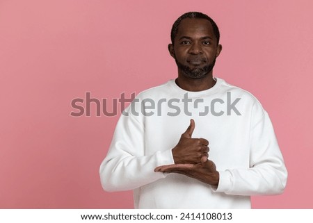 Deaf mute black man wearing white sweatshirt gesturing sign language Royalty-Free Stock Photo #2414108013