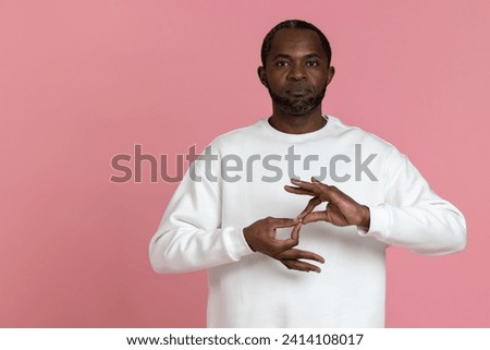 Deaf mute black man wearing white sweatshirt gesturing sign language Royalty-Free Stock Photo #2414108017