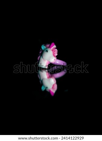 unicorn toy ring in black background