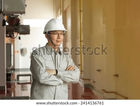 Engineers technicians man wearing professional helmets working in powerhouse or power plant. Royalty-Free Stock Photo #2414136761