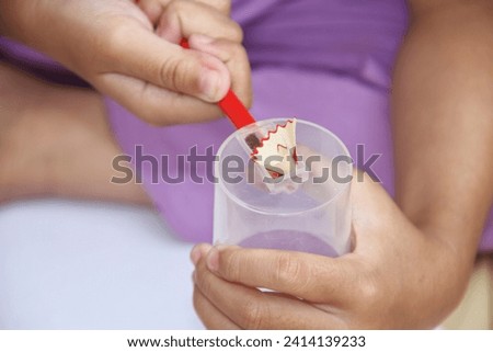 close up photo of a girl's hand sharpening colored pencils.