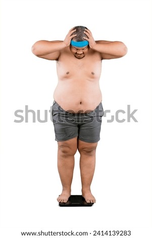 Picture of young fat man checking his weight while standing on the scale isolated on white