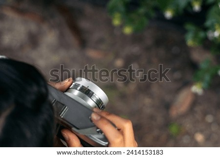 Close-up of an unrecognizable woman taking photos with analog camera