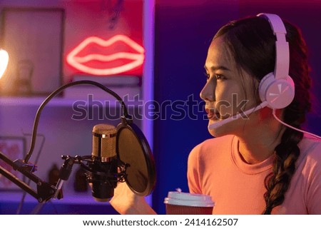 Host channel of creative broadcast listening the music on social media with listeners holding coffee up, wearing pastel color headphones, using mic radio record by camera at neon studio. Stratagem.