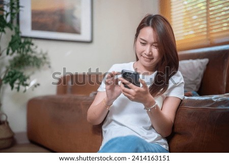 Happy beautiful woman sitting alone on the floor in the lounge and using technology to network.